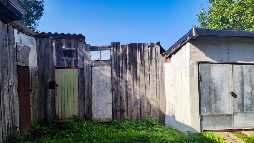 Старые деревянные сараи и ворота с металлической обшивкой