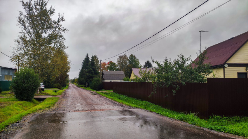 Гравийная дорога между жилыми домами в посёлке после дождя