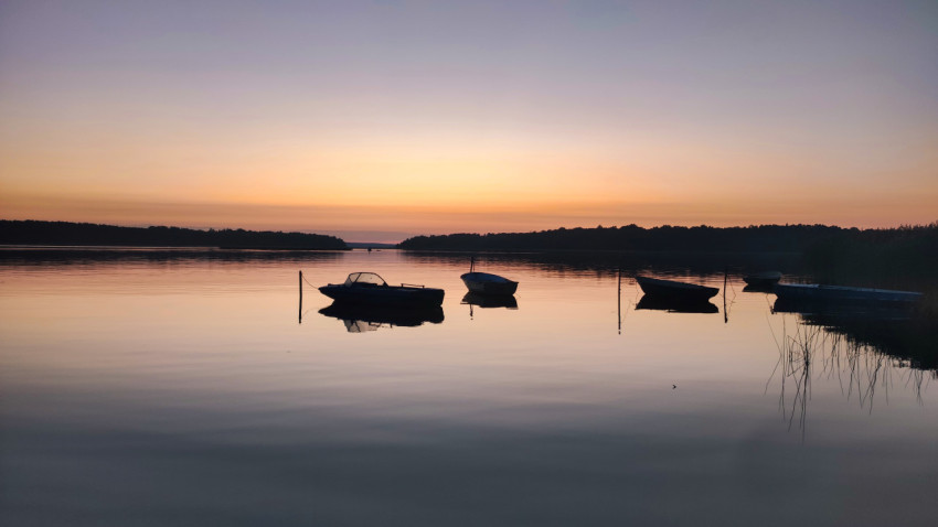 Лодки на спокойной воде во время заката