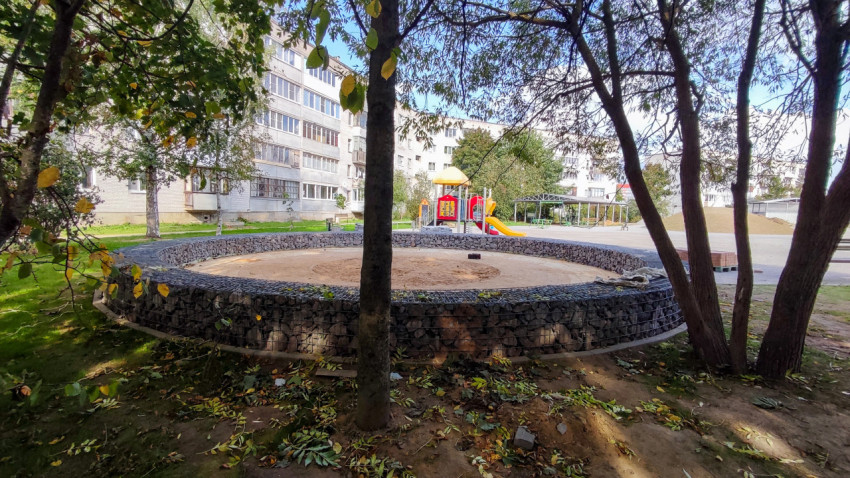 Детская площадка во дворе жилого квартала с габионами и зелёными насаждениями