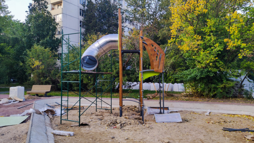 Монтаж игровой горки на детской площадке во дворе жилого дома