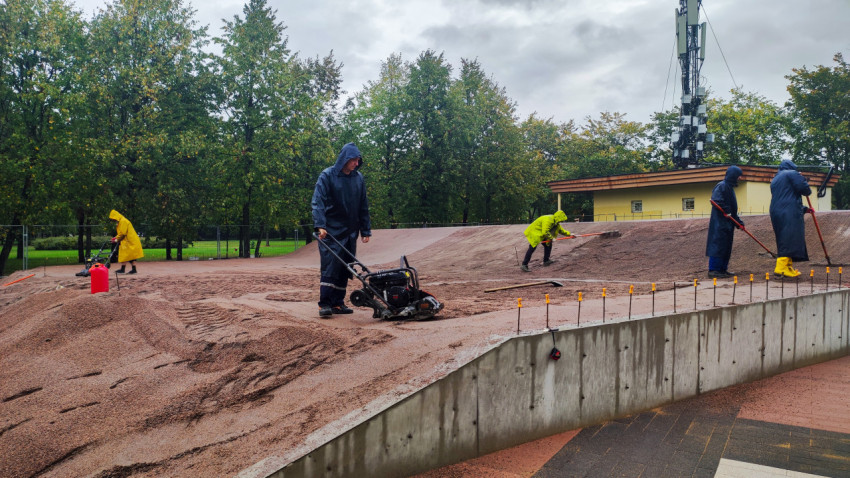 Рабочие выполняют уплотнение щебёночного слоя на площадке