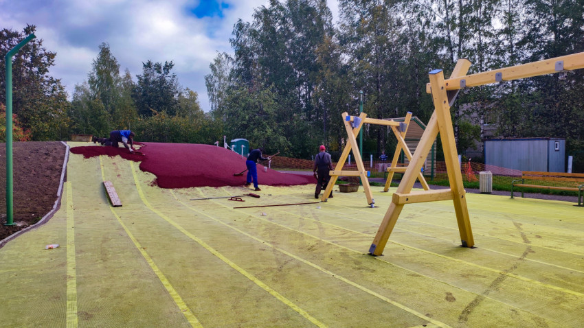 Укладка резинового покрытия на наклонной зоне детской площадки