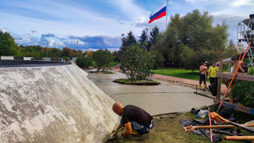 Рабочие укладывают бетон на пешеходной дорожке парка