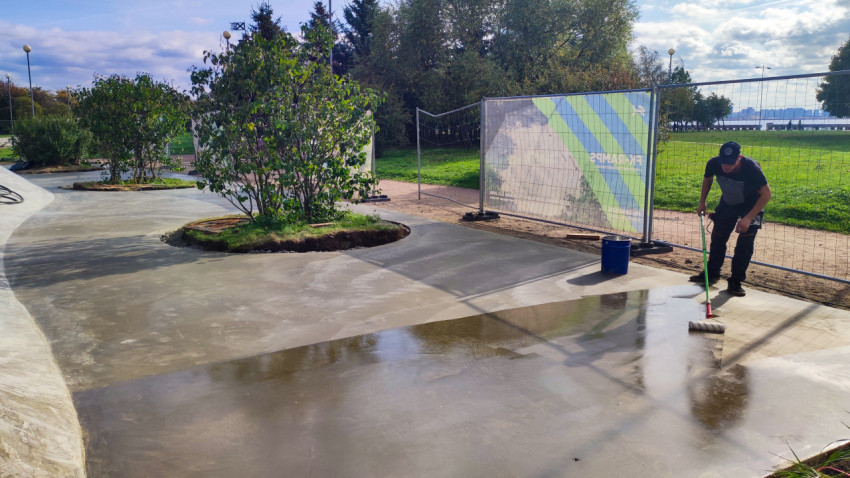 Рабочий наносит защитное покрытие на свежеуложенный бетон