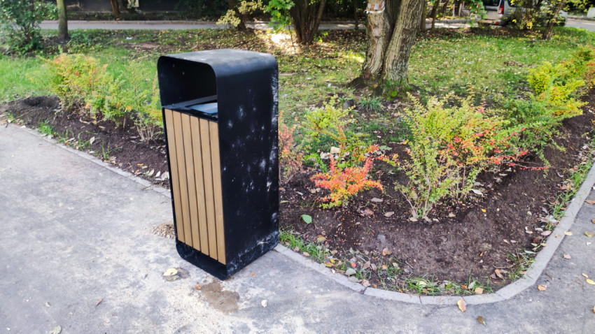 Урна и клумба на пешеходной аллее во дворе жилого квартала