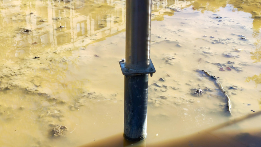 Металлическая опора детского комплекса в стоячей воде