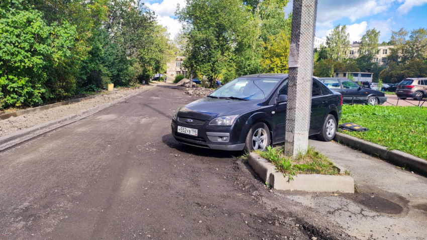 Улица с частично разобранным покрытием и припаркованными автомобилями