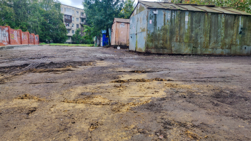Поверхность двора перед асфальтированием с металлическими гаражами