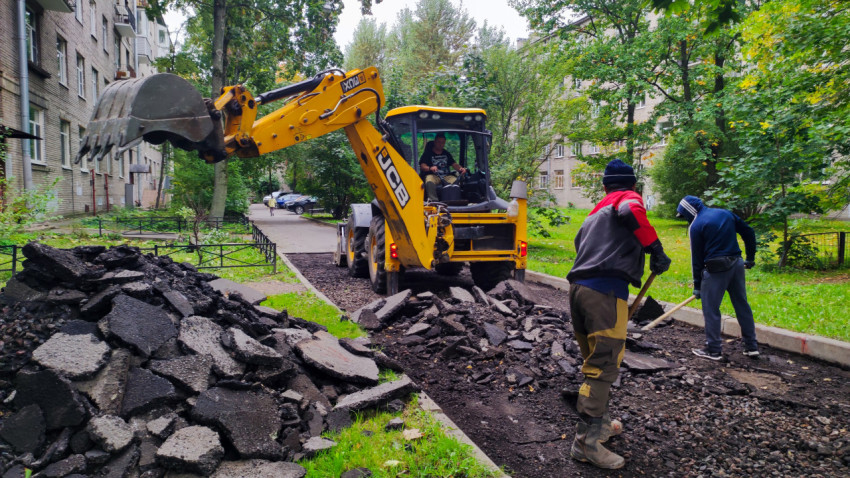Разработка старого асфальта экскаватором во дворе