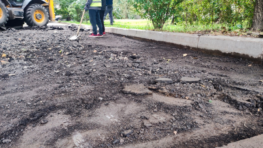 Рабочие очищают основание после снятия асфальта