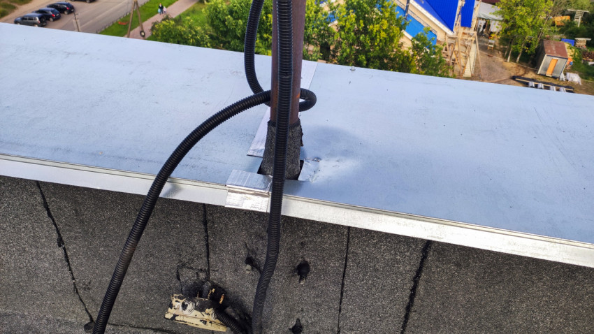 Электропроводка и кабельные вводы на металлическом парапете крыши