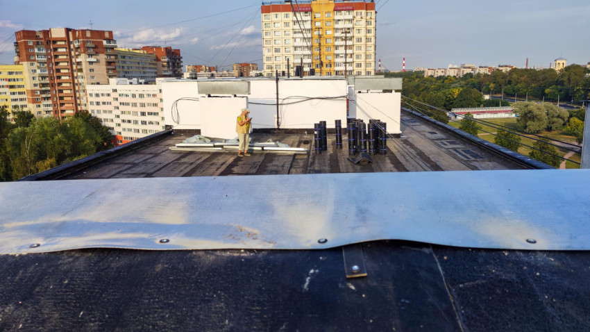 Общий вид кровли жилого дома с рулонным покрытием и металлическим парапетом