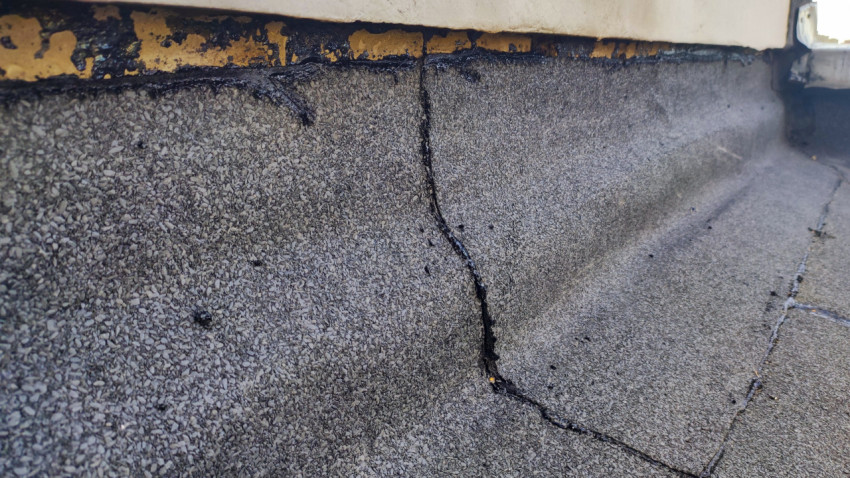 Трещина и нарушение герметизации рулонной кровли у стенового примыкания