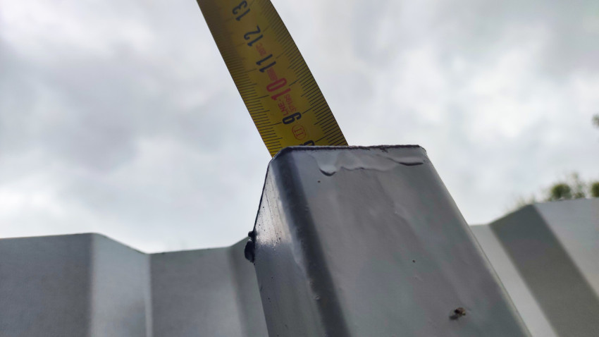 Замер высоты металлической стойки забора