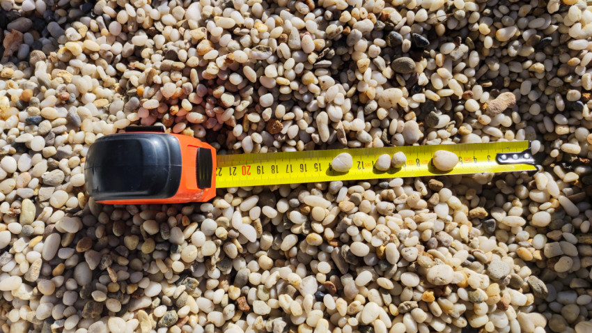 Рулетка и образцы щебня на измерительной ленте