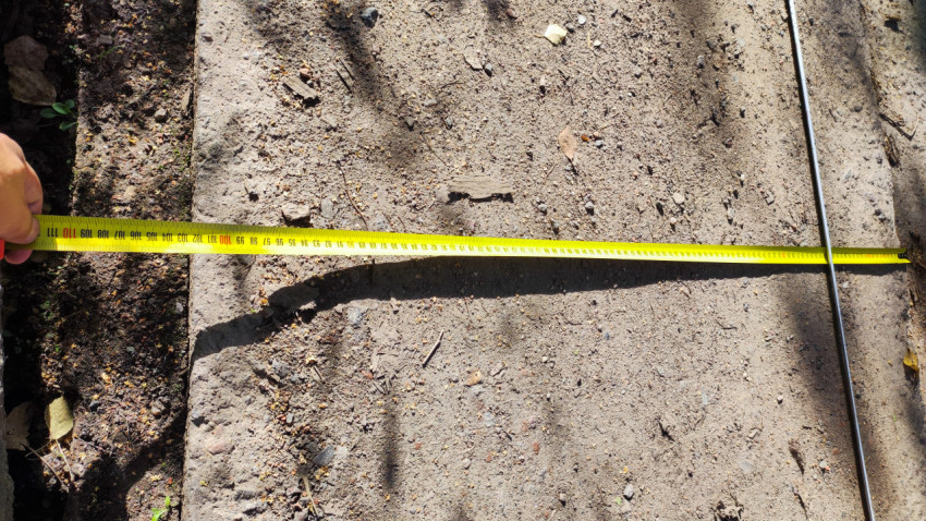 Измерение ширины бетонной плиты рулеткой