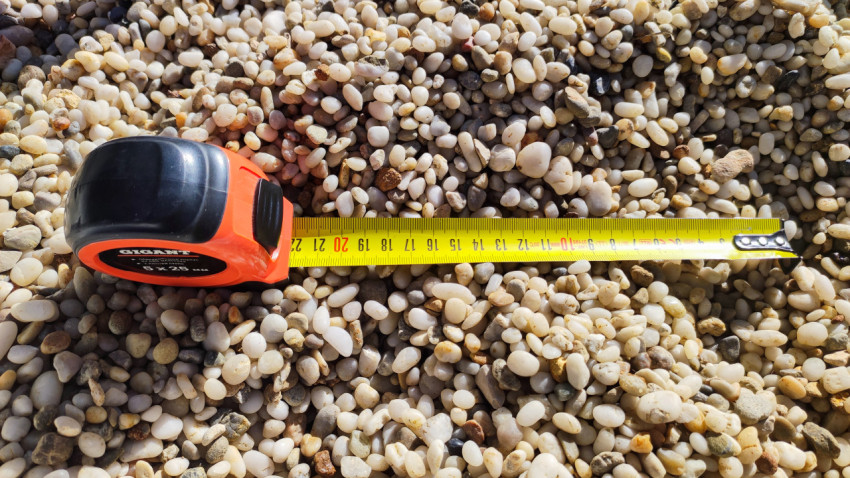 Рулетка на гравийной поверхности, измерение диаметра щебня