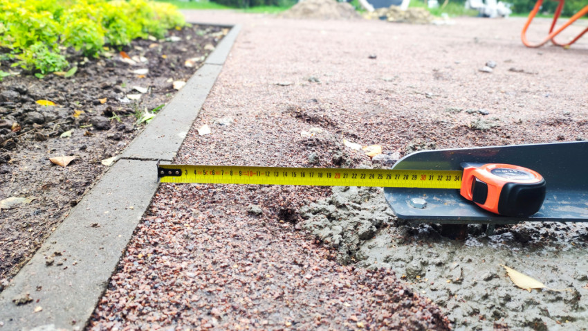 Измерение расстояния между бордюром и основанием металлической конструкции