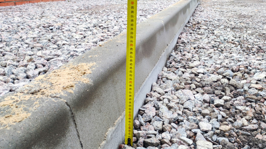 Измерение высоты бордюра на этапе благоустройства двора