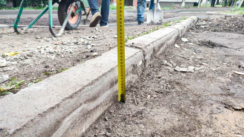 Измерение высоты бордюра при благоустройстве двора