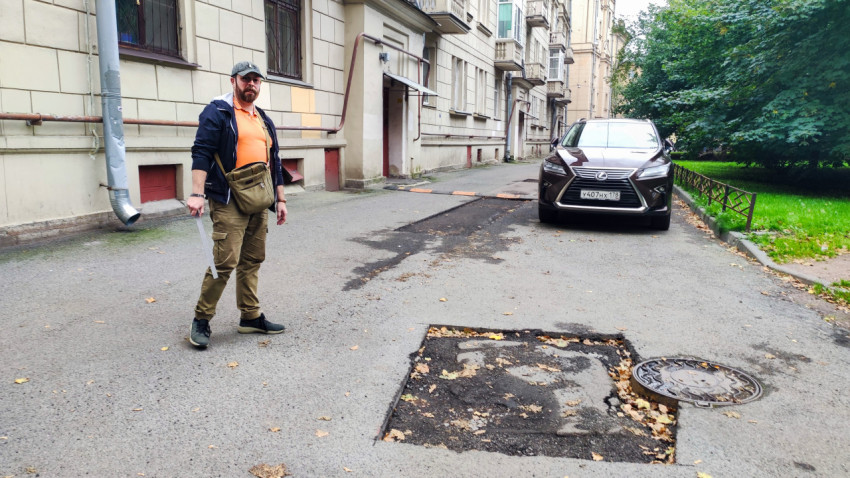 Специалист проводит визуальный осмотр дорожного покрытия во дворе