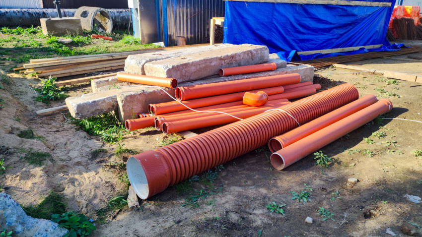 Оранжевые дренажные и канализационные трубы на стройплощадке