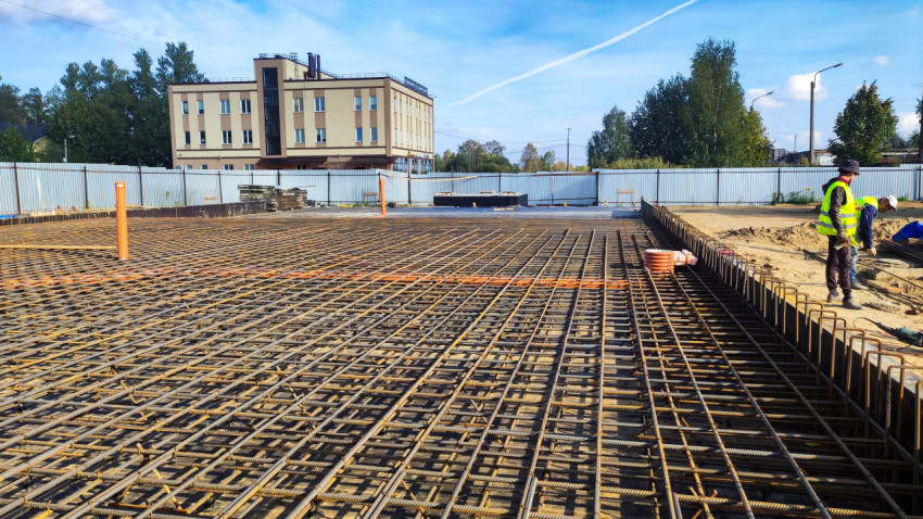 Рабочие выполняют укладку арматуры на строительной площадке