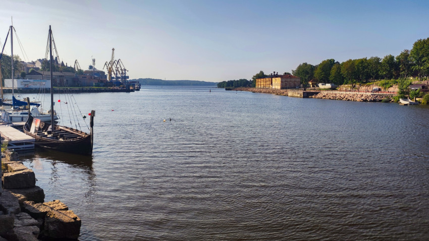 Портовые краны и историческое здание на берегу бухты в Выборге