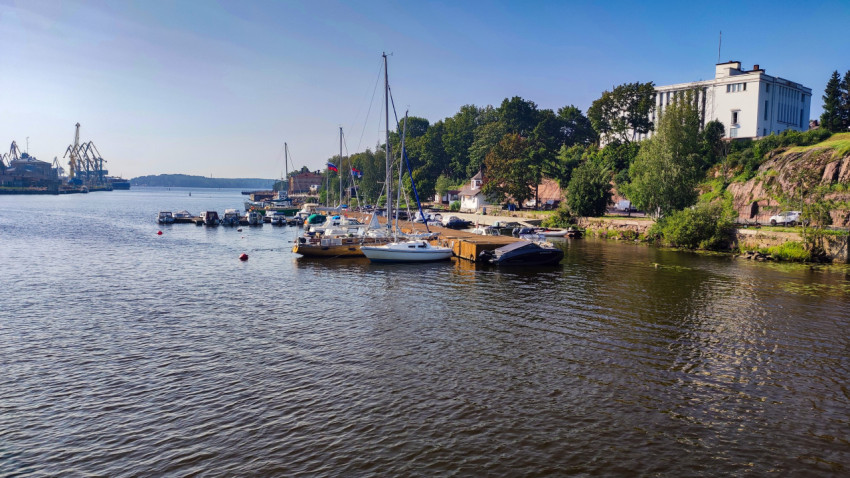 Панорама бухты с яхтами и белым зданием на холме в Выборге