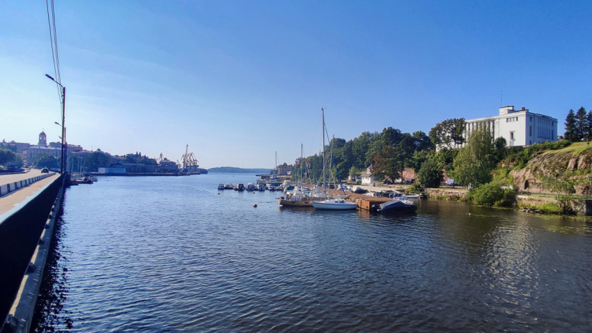 Пристань с яхтами у подножия холма и белое здание в Выборге