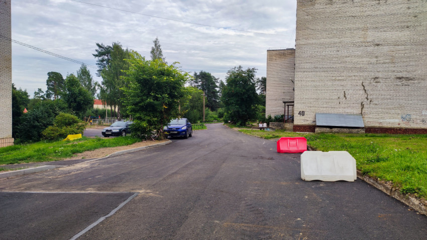 Асфальтовая дорога во дворе с временными ограждениями