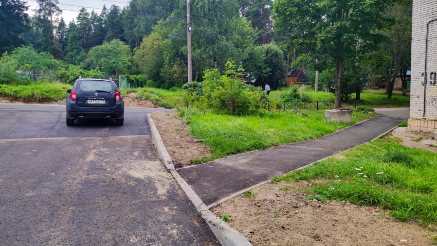 Дворовая дорога с новым асфальтовым покрытием и тротуаром