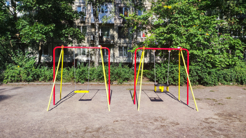 Пустые качели на детской площадке во дворе