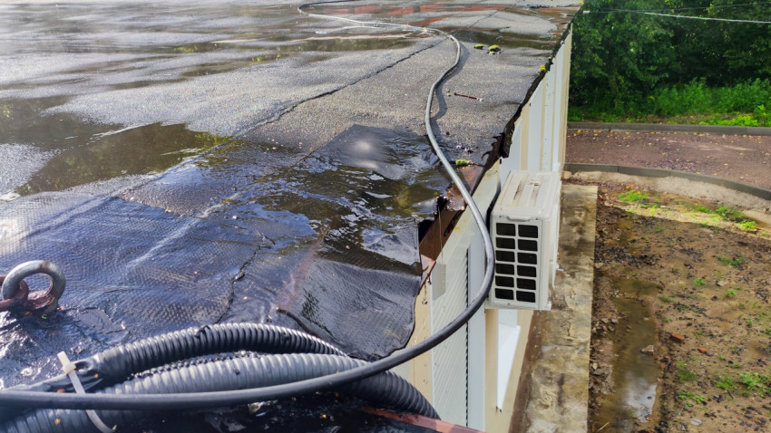 Крыша здания с кондиционером и кабелями