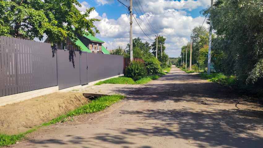 Сельская улица с жилыми домами и линиями электропередачи