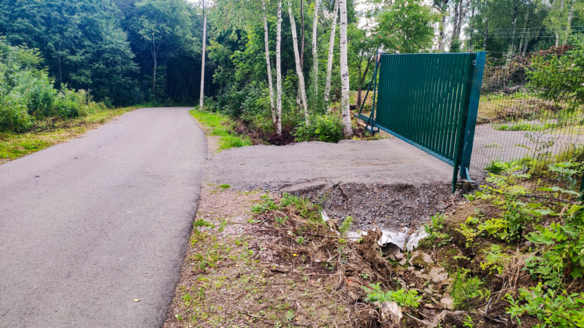 Асфальтовая дорога с канавой у ограды