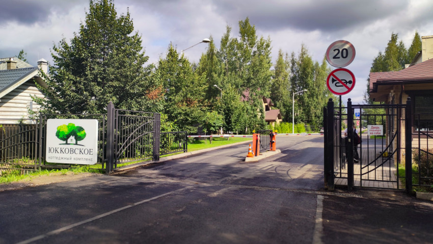 Въезд в коттеджный комплекс «Юкковское» с воротами и шлагбаумом