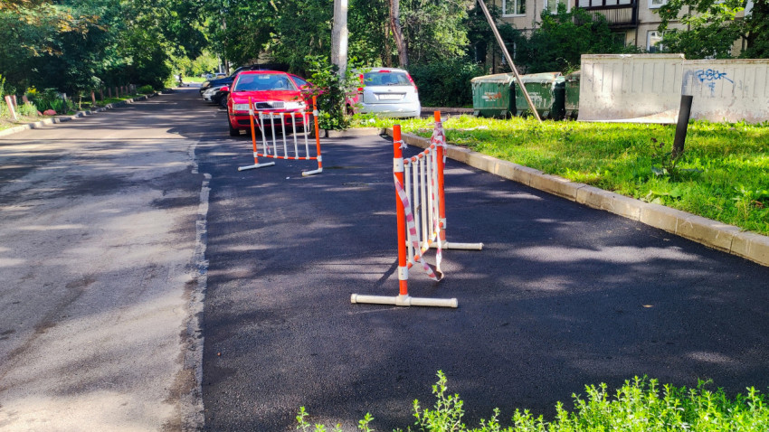 Дворовая дорога с ограждениями на свежем асфальте