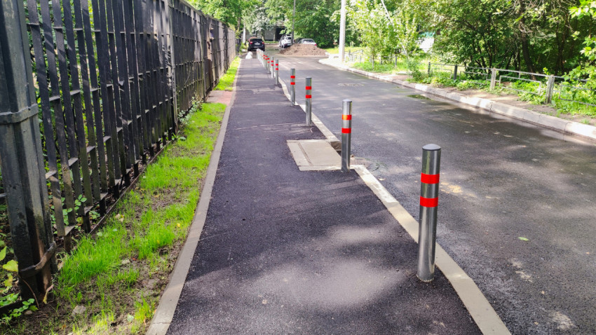 Ограничительные столбы вдоль тротуара и люк