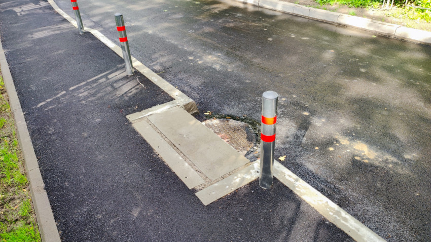 Люк на проезжей части и ограничительные столбы
