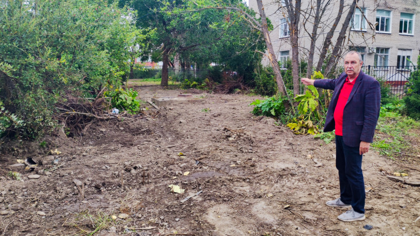 Мужчина показывает на участок с расчисткой территории