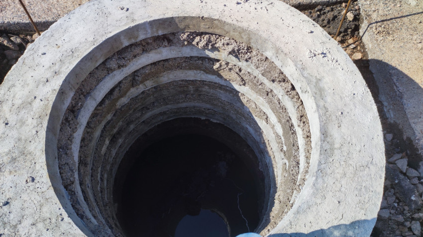 Внутренний вид бетонного колодца с водой на дне