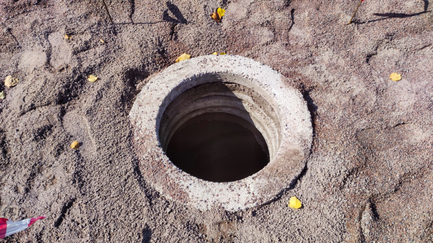 Бетонный люк, засыпанный щебнем и грунтом