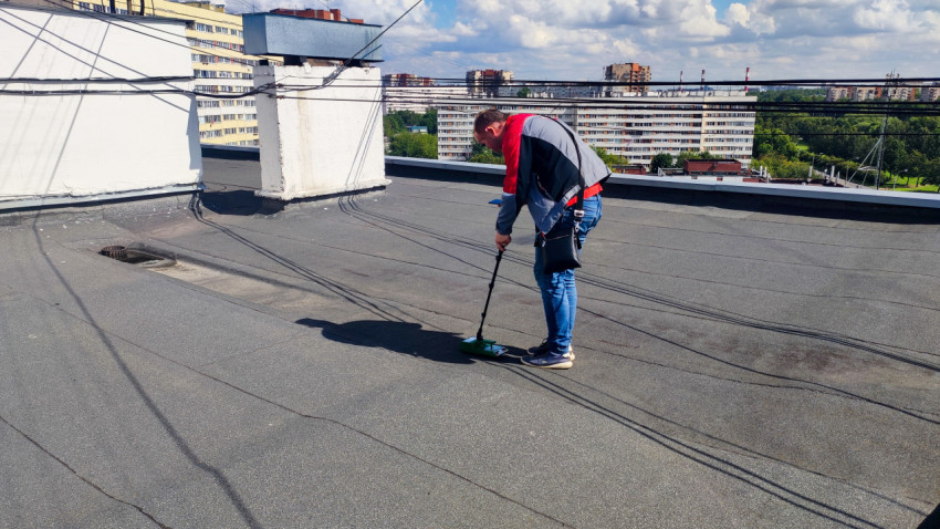 Специалист обследует кровлю с прибором Tramex