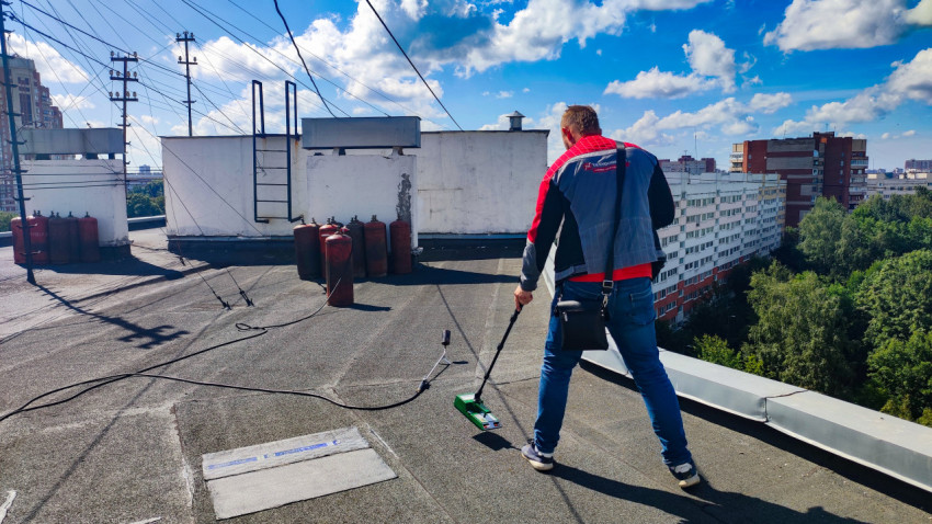 Специалист проверяет крышу влагомером Tramex