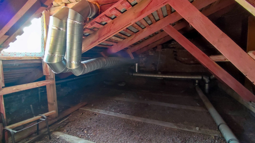 Чердак здания с установленными вентиляционными трубами