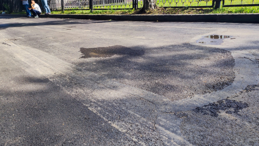 Участок асфальта с лужами после ремонта дороги