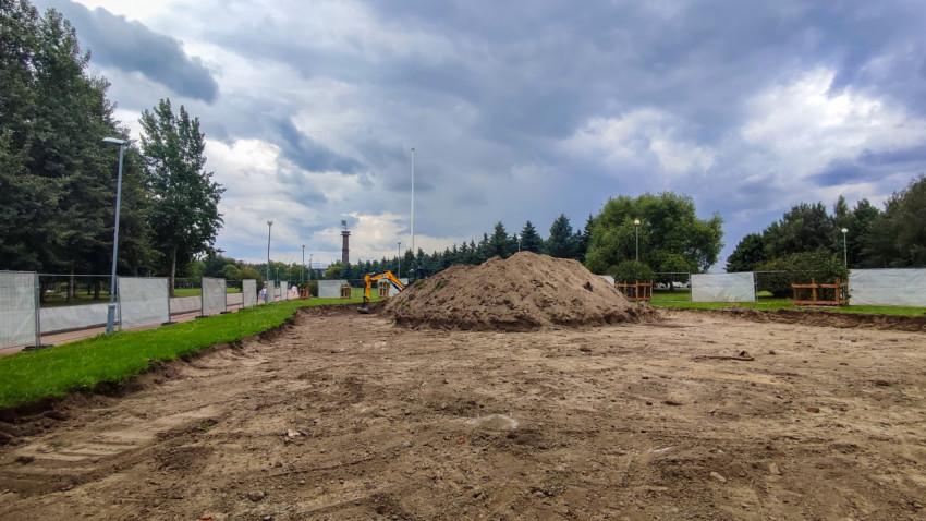 Экскаватор и насыпь грунта на стройплощадке в парке