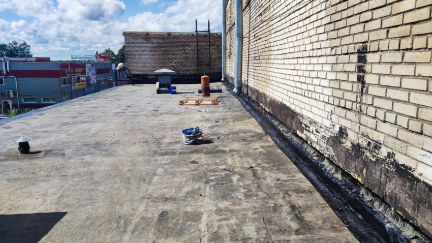 Участок крыши с вентиляционными выходами и строительными материалами